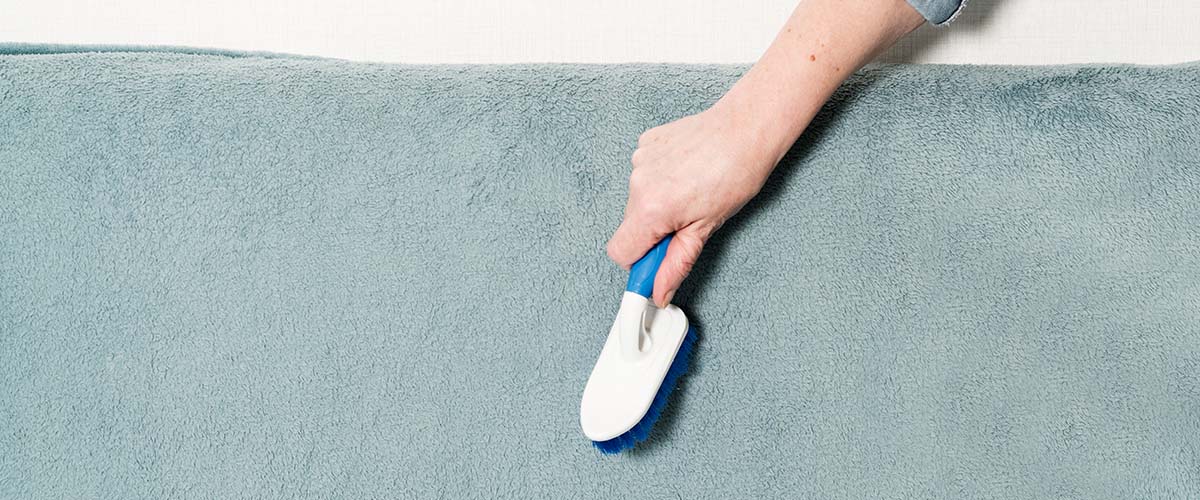 woman brushing a blue carpet